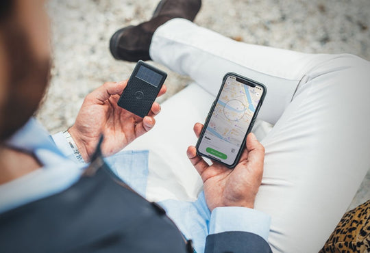 man holding a tracker for wallets and iphone