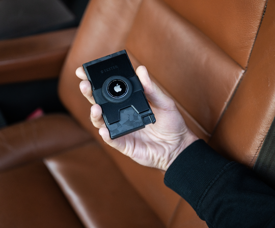 Close up of a hand holding Ekter's Carbon Cardholder for AirTag